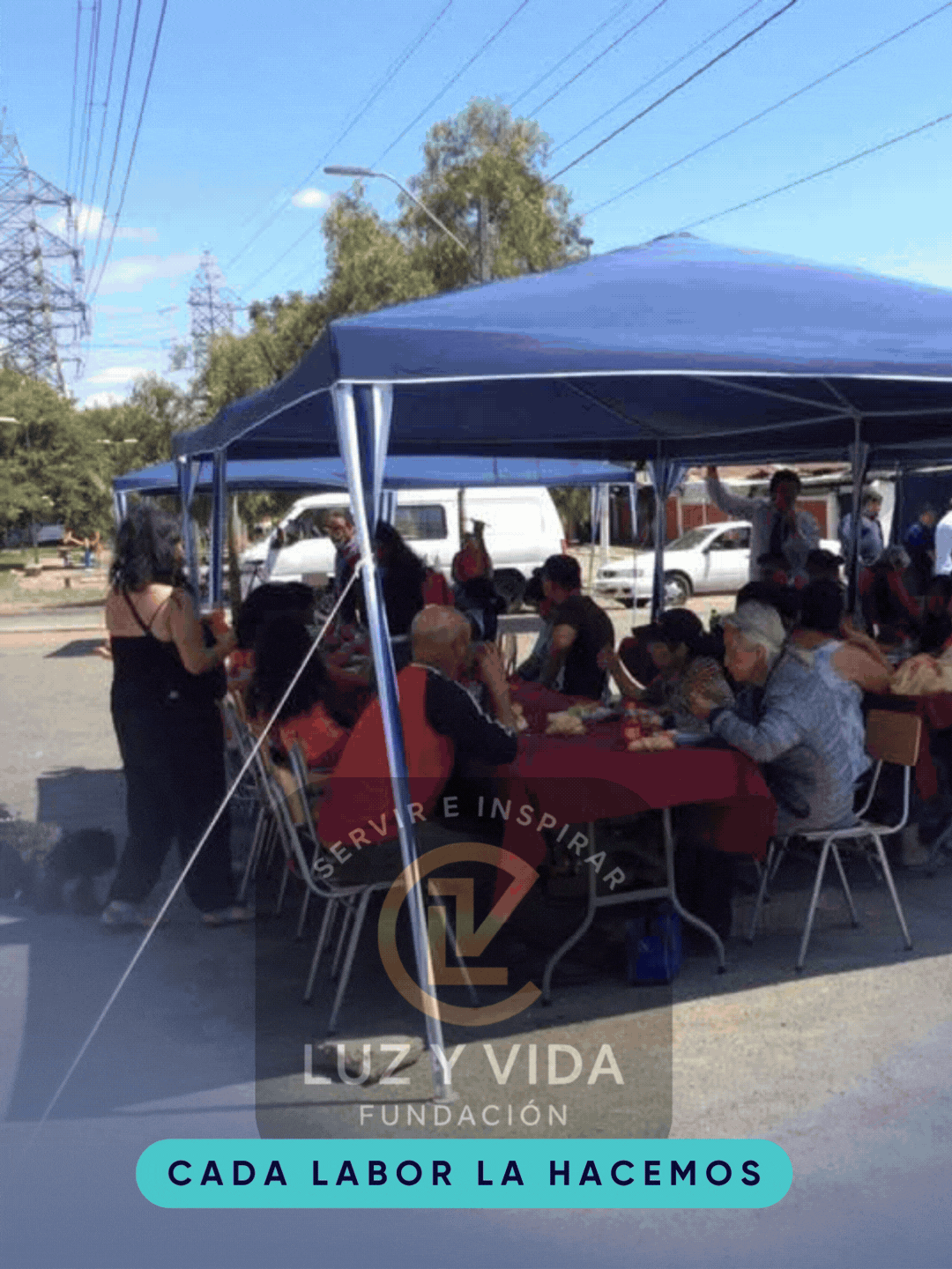 Actividad comunitaria de Fundación Luz y Vida Chile: compartir de almuerzo bajo una carpa al aire libre